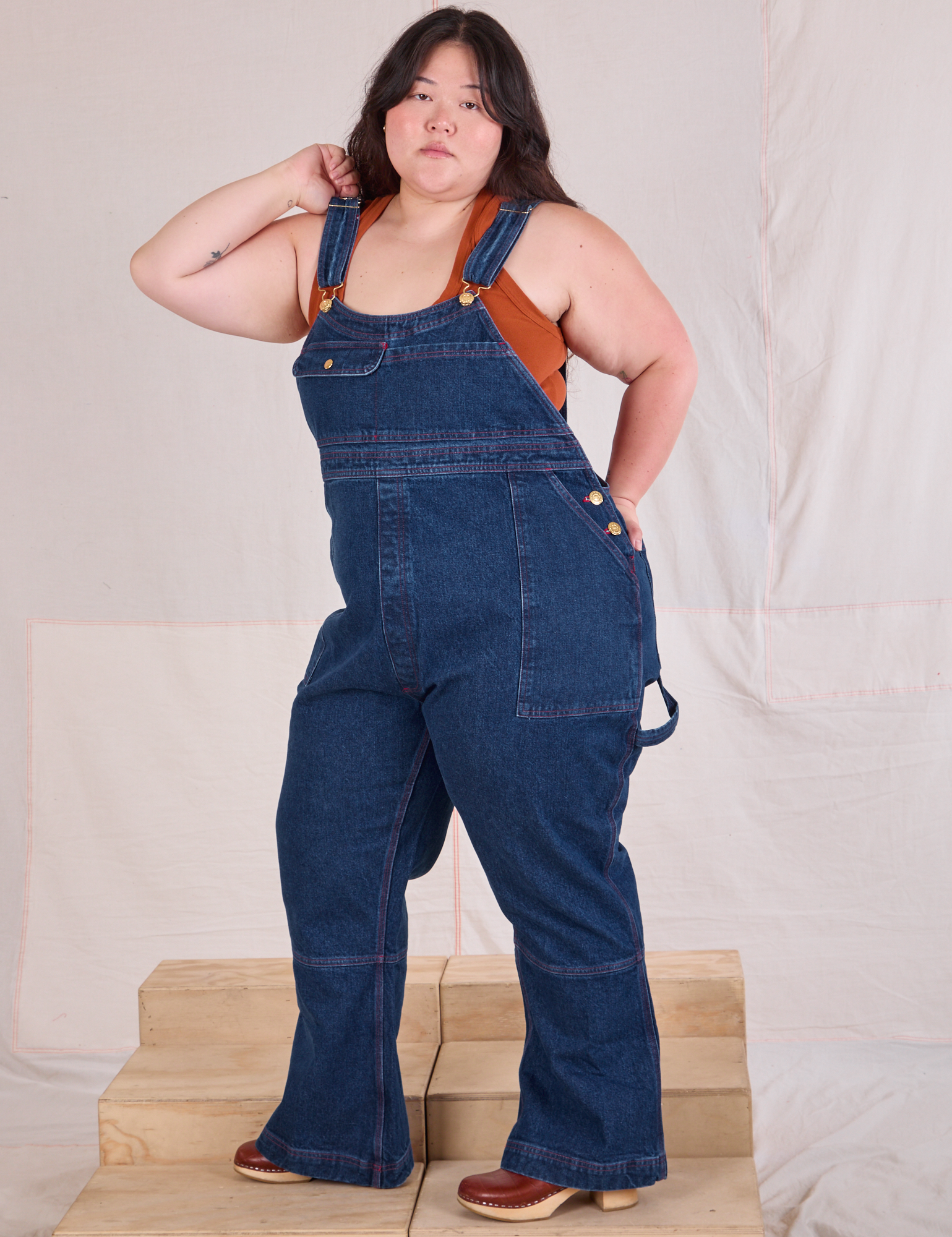 Carpenter Overalls in Dark Wash angled front view worn by Ashley