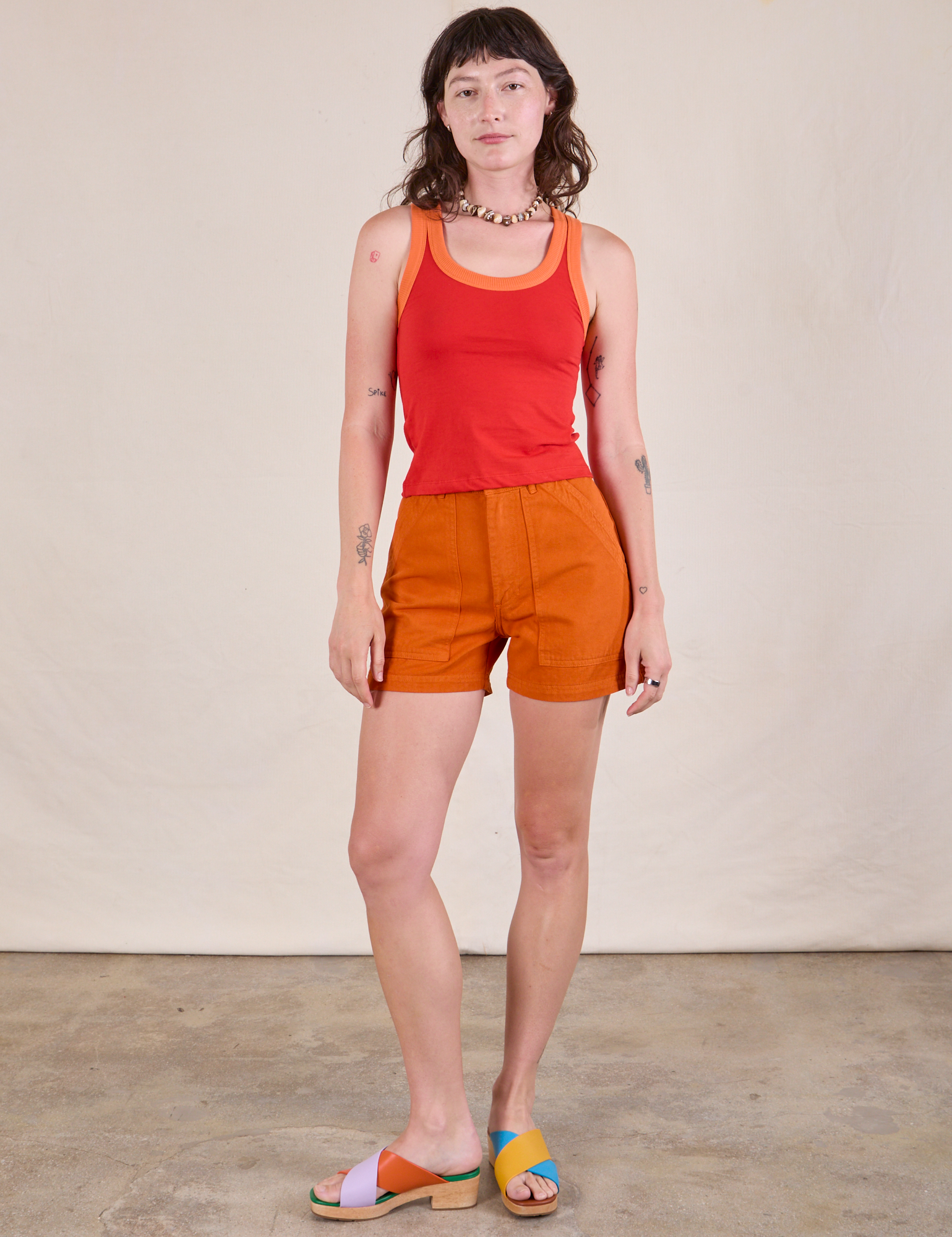Alex is wearing Colorblock Cropped Tank in Mustang Red and burnt orange Work Shorts
