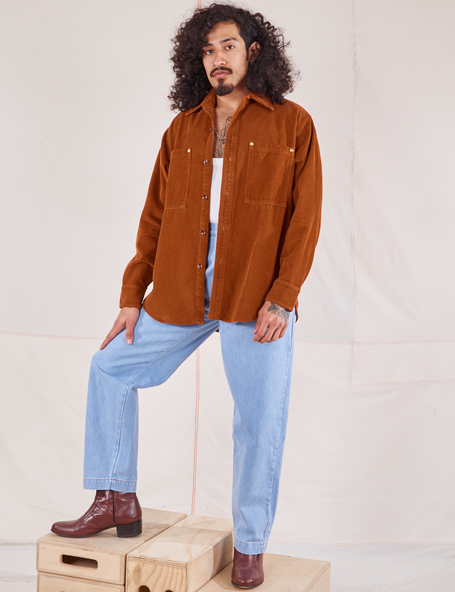 Jesse is wearing Corduroy Overshirt in Burnt Terracotta and light wash Denim Trouser Jeans
