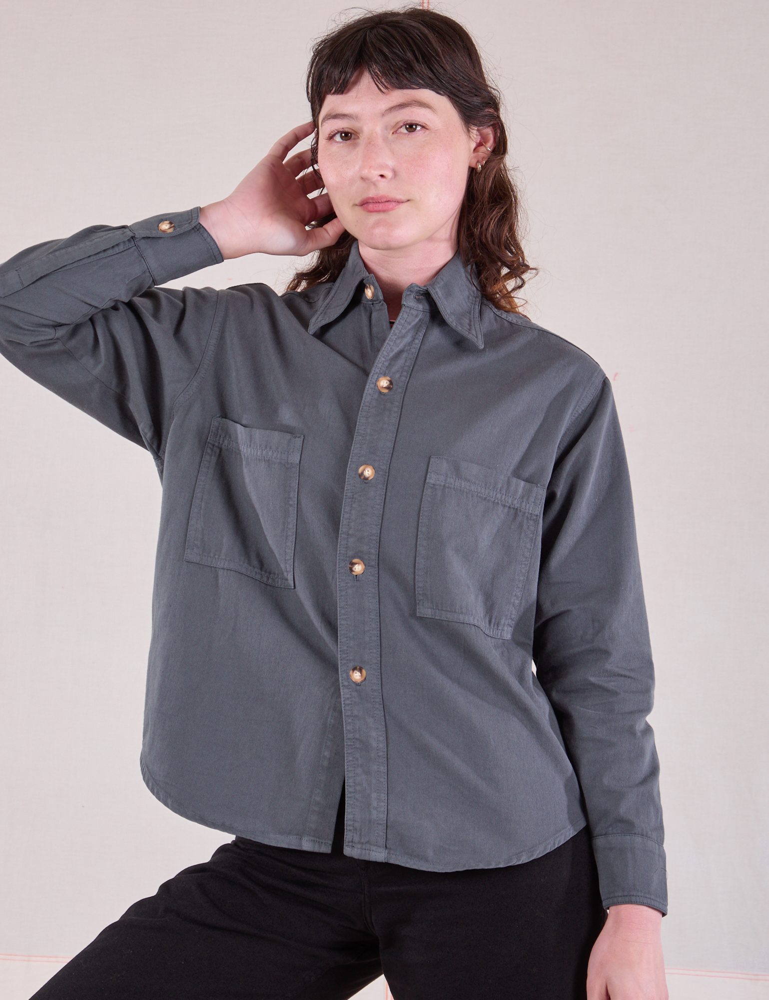 Alex is wearing a buttoned up Cropped Overshirt in Slate Grey