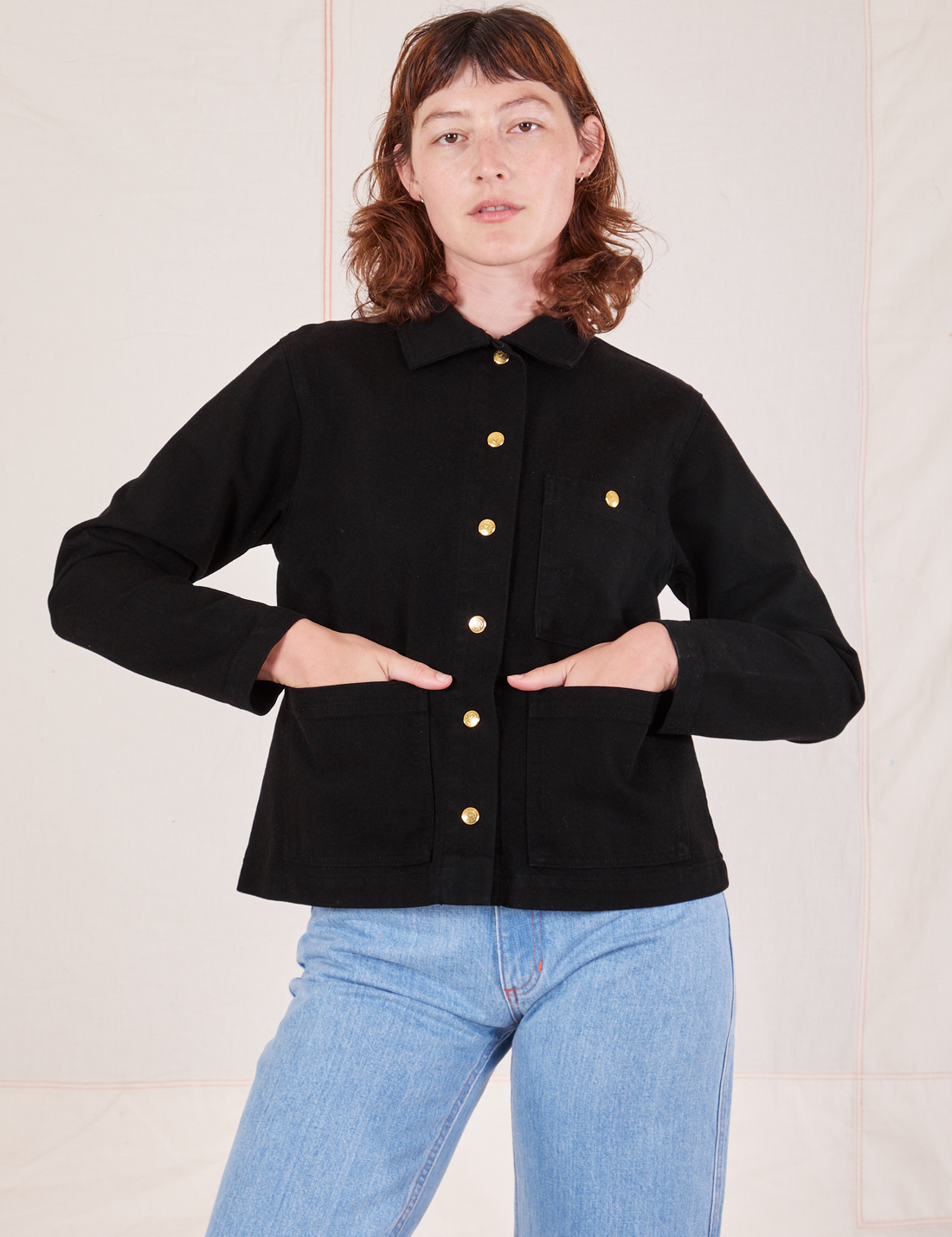 Alex is wearing Denim Work Jacket in Basic Black and has both her hands in the pockets