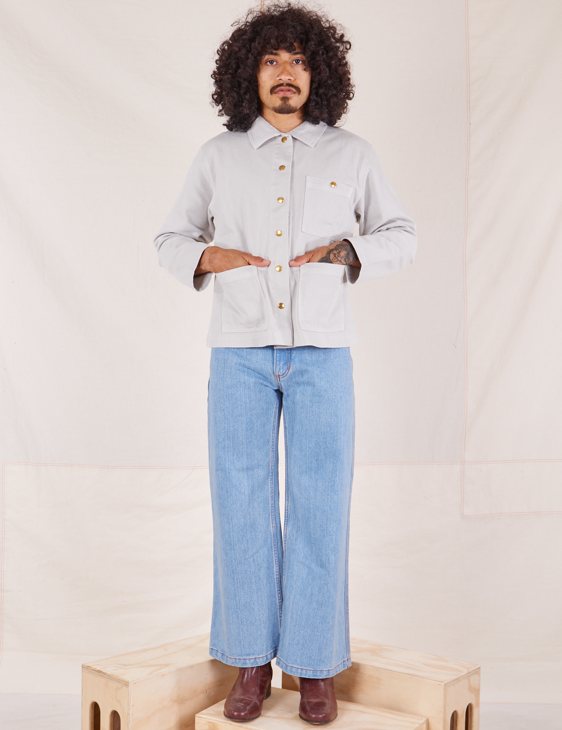 Jesse is wearing a buttoned up Denim Work Jacket in Dishwater White paired with light wash Sailor Jeans