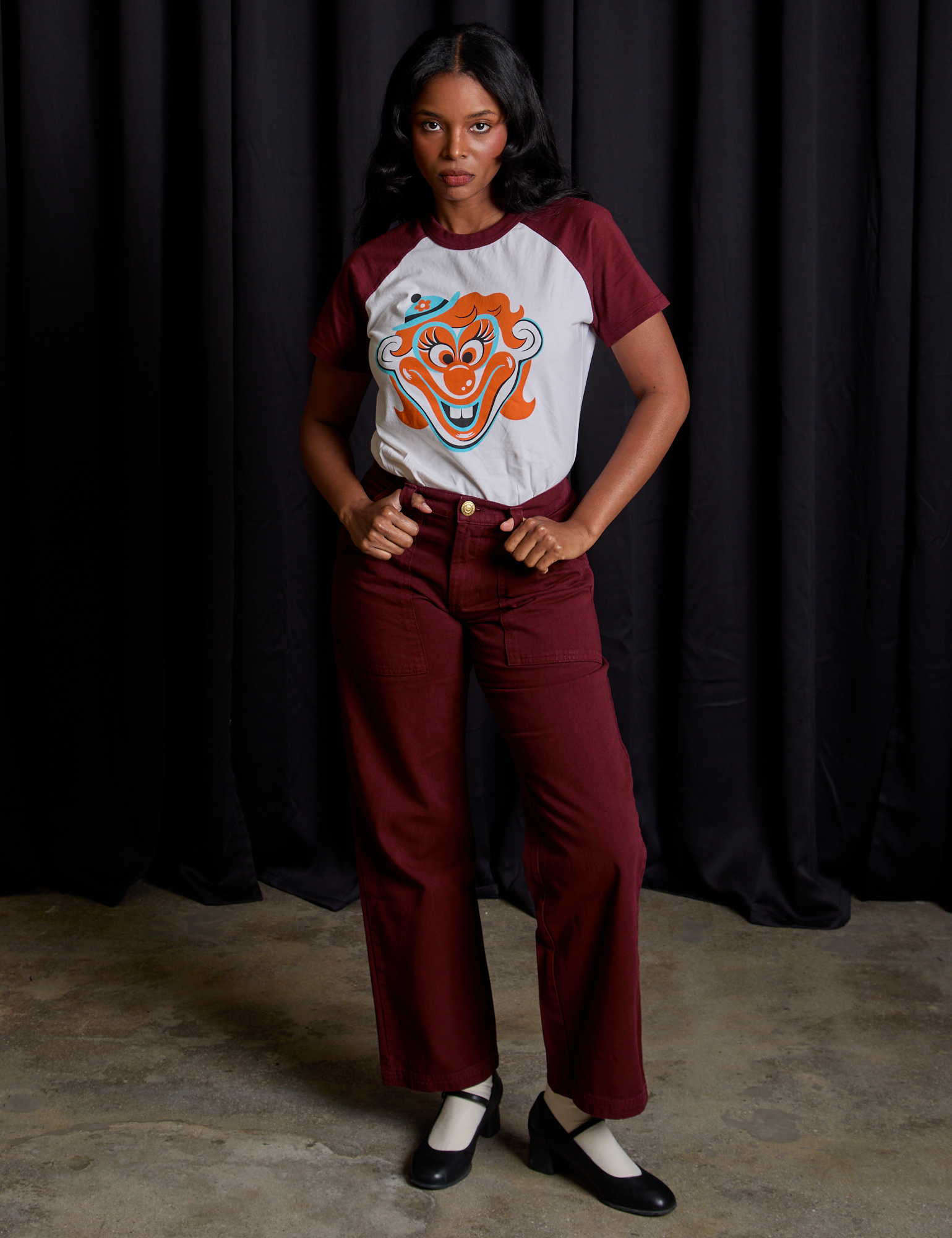 Kandia is wearing Raglan Tee in Clown paired with red wine Mid-Rise Work Pants