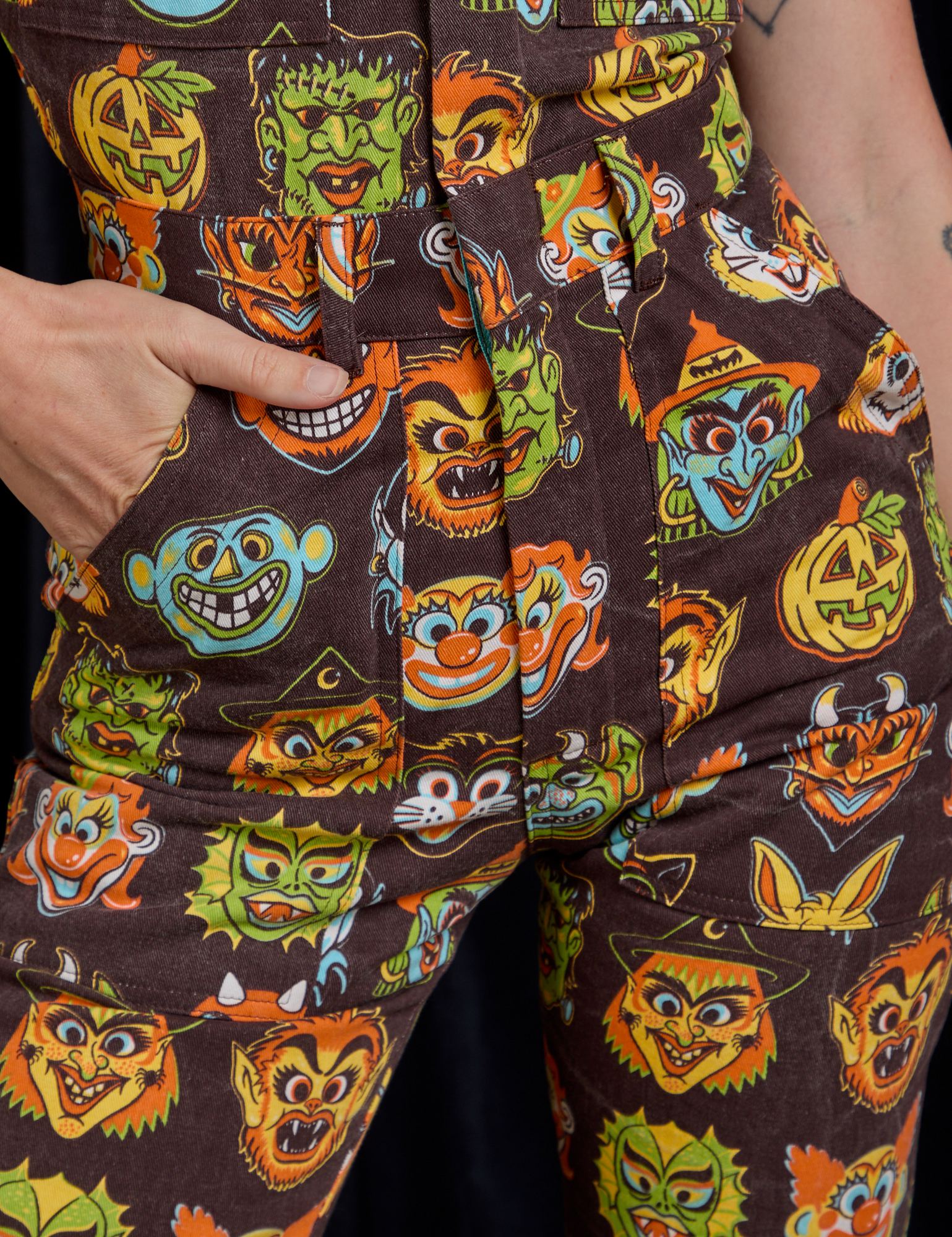 Close up of Alex&#39;s hand in the front pocket of Short Sleeve Jumpsuit in Halloween Masks