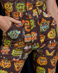 Close up of Alex's hand in the front pocket of Short Sleeve Jumpsuit in Halloween Masks