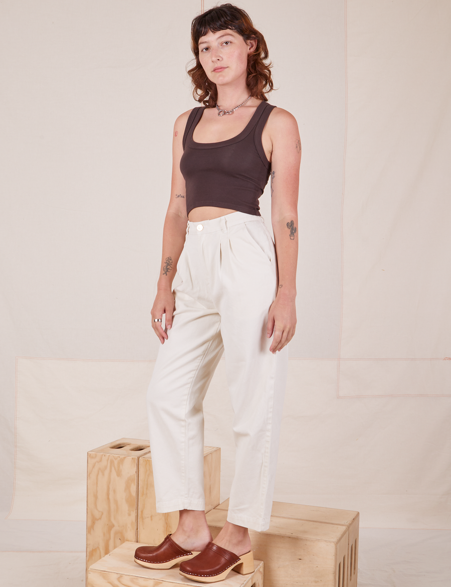 Angled view of Heavyweight Trousers in Vintage Off-White and espresso brown Cropped Tank Top worn by Alex.