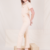 Side view of Heritage Short Sleeve Jumpsuit in Natural worn by Alex