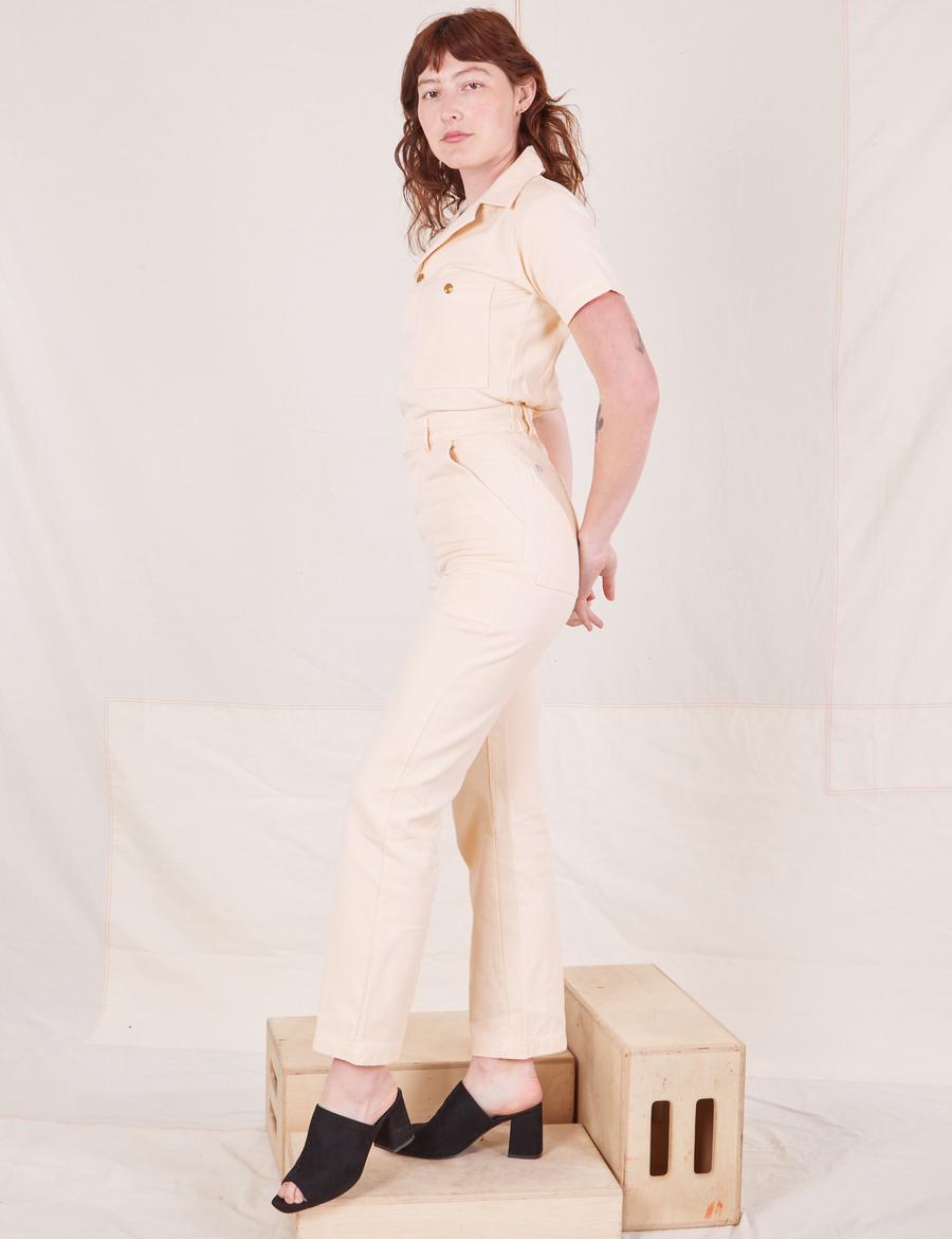 Side view of Heritage Short Sleeve Jumpsuit in Natural worn by Alex