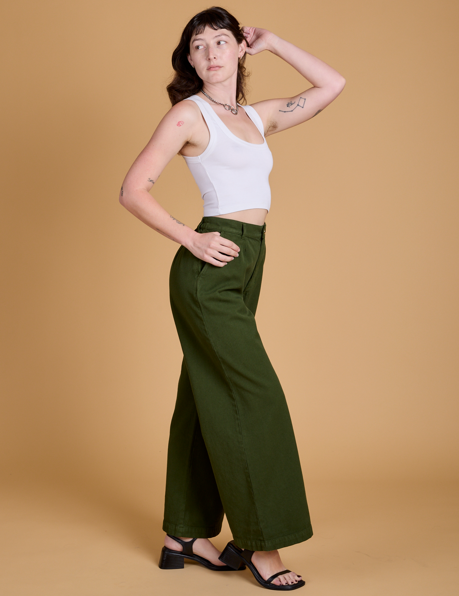 Side view of Heritage Wide Leg Trousers in Evergreen and vintage tee white Cropped Tank