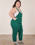 Side view of Original Overalls in Mono Hunter Green and vintage off-white Cropped Tank Top worn by Ashley