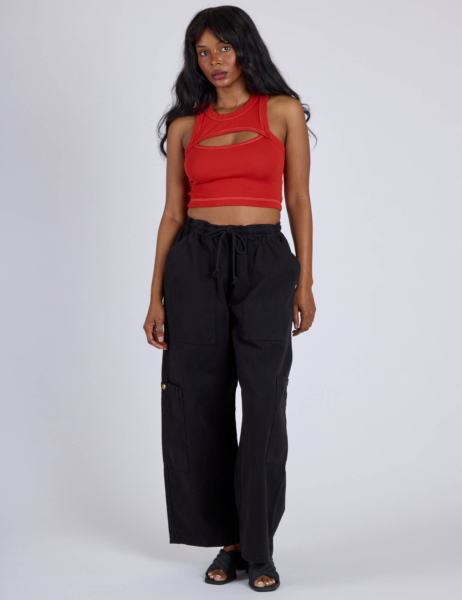 Kandia is wearing Porthole Tank in Mustang Red and Black Drop Pocket Cargo Pants