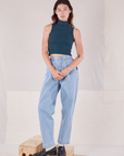 Alex is wearing Sleeveless Essential Turtleneck in Lagoon and light wash Trouser Jeans