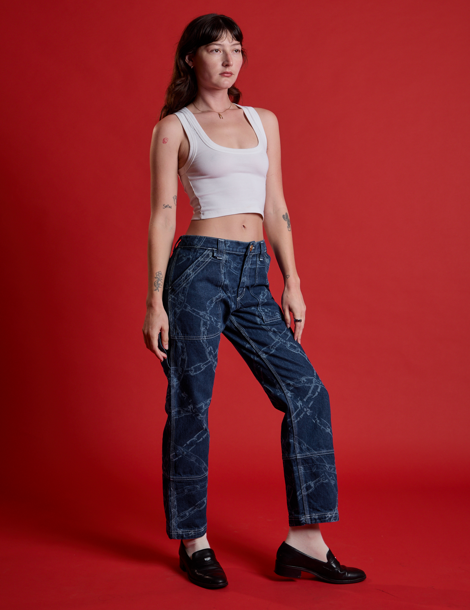 Angled front view of Mid-Rise Carpenter Jeans in Chain Link and Cropped Tank in Vintage Tee White