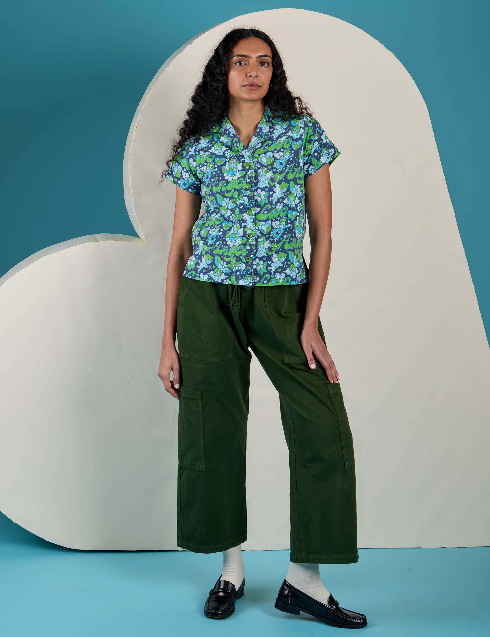 Shahana is wearing Angel Print Pantry Button-Up and evergreen Drop Pocket Cargo Pants
