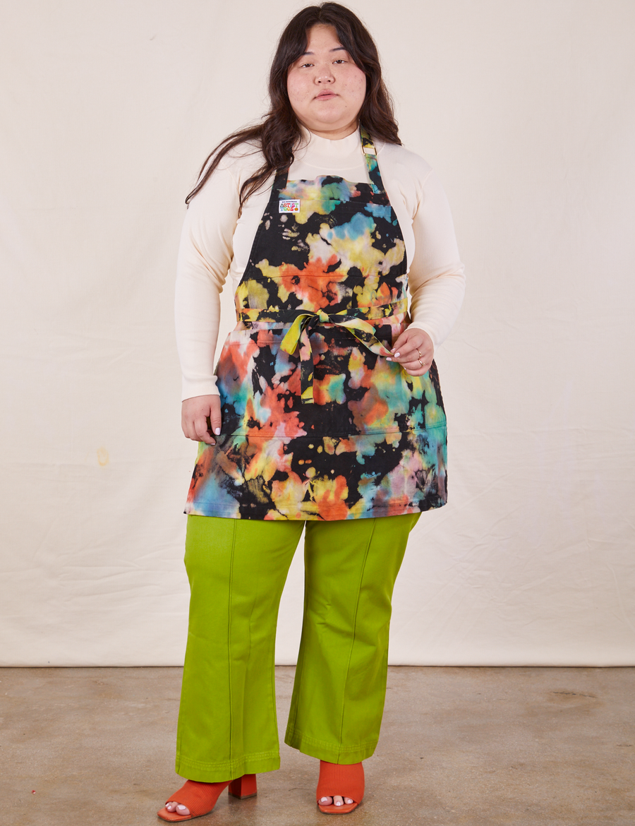 Ashley is wearing Artist Togs Full Apron in Rainbow Magic Waters with the waist straps tied in a bow at the front.
