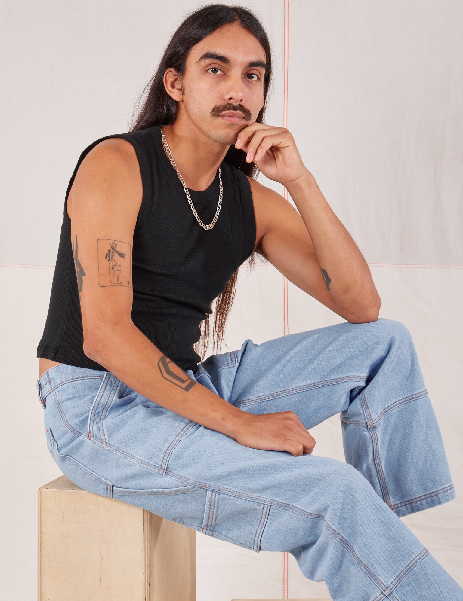 Anthony is wearing Muscle Tee in Basic Black and light wash Carpenter Jeans