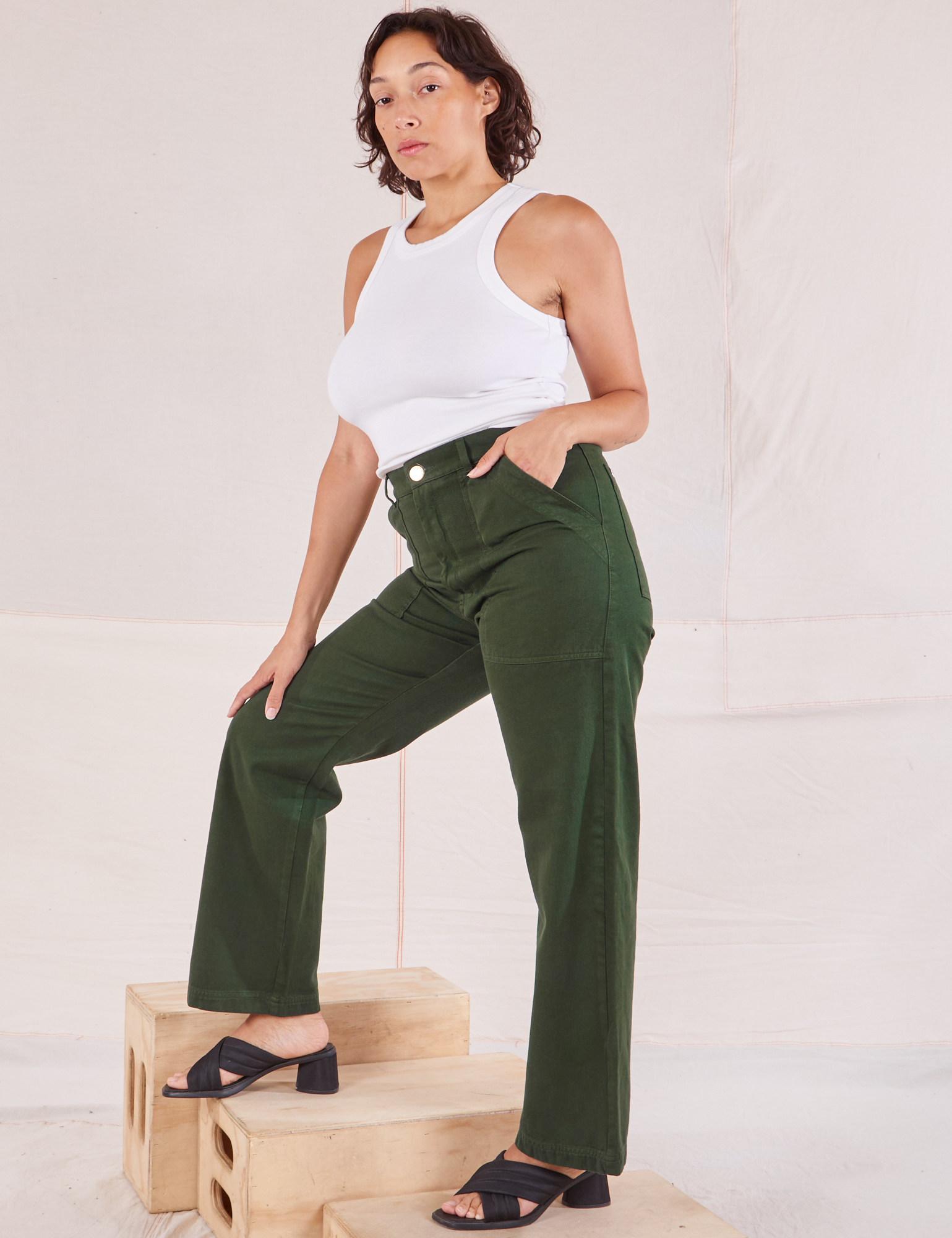 Side view of Organic Work Pants in Swamp Green and Racerback Tank in vintage tee off-white on Tiara