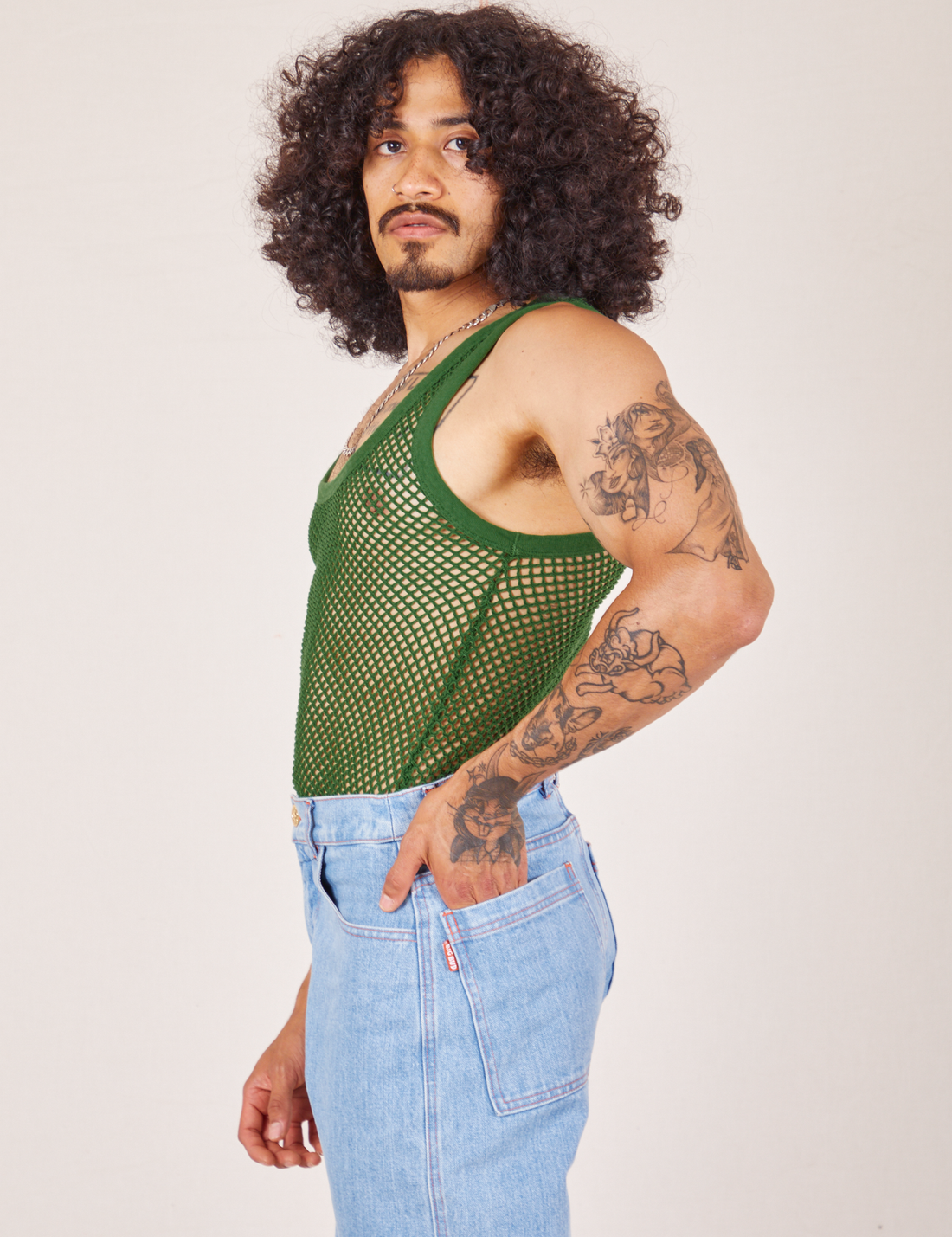 Side view of Mesh Tank Top in Lawn Green and light wash Sailor Jeans worn by Jesse