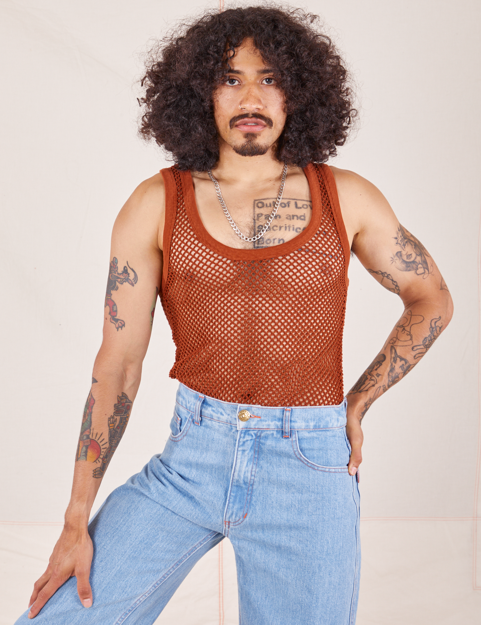 Jesse is wearing Mesh Tank Top in Burnt Terracotta and light wash Sailor Jeans