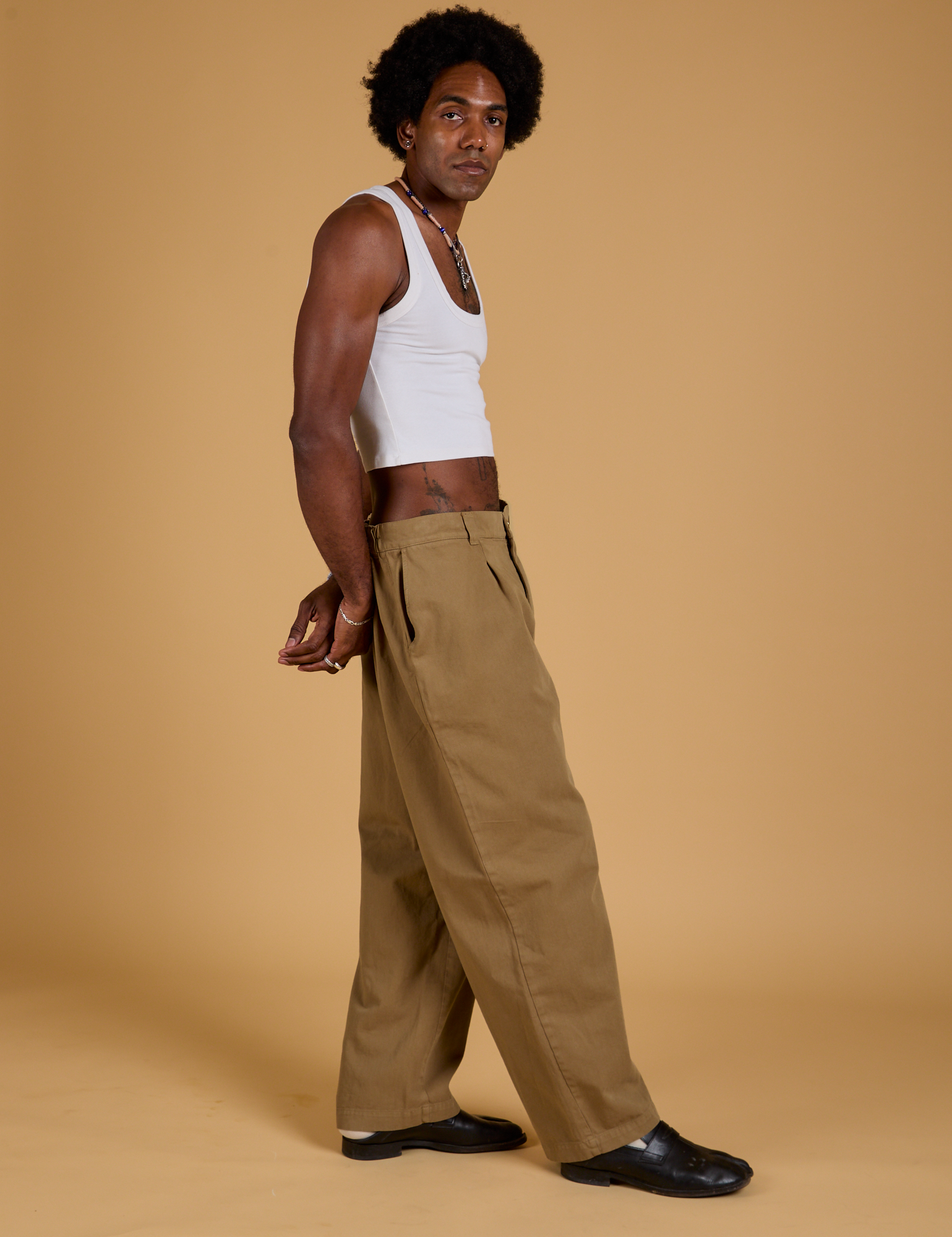 Side view of Baggy Mid-Rise Trousers in Desert Brown and vintage tee-white  Cropped Tank