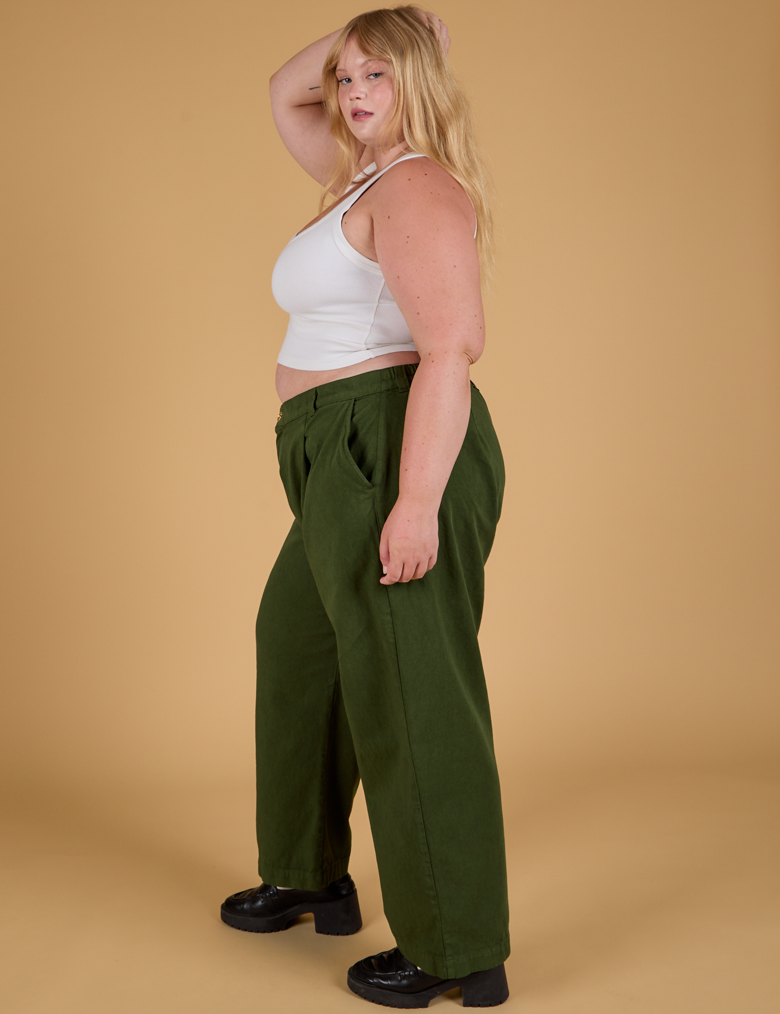 Side view of Baggy Mid-Rise Trousers in Evergreen and vintage tee white Cropped Tank on Juliet