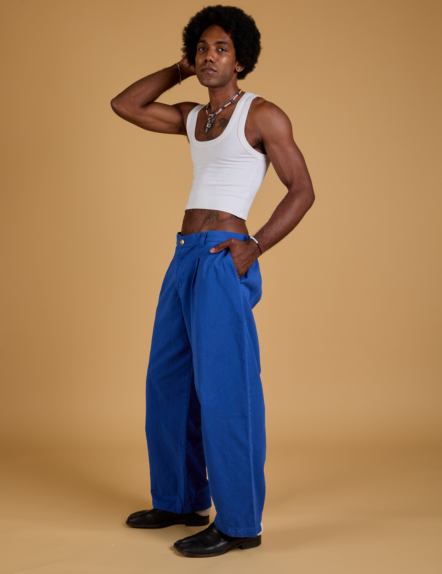 Side view of Baggy Mid-Rise Trousers in Royal Blue and vintage tee white Cropped Tank on Jerrod