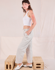 Side view of Mid-Rise Pleated Trousers in Stone White and Cropped Tank in Vintage Tee Off-White on Alex