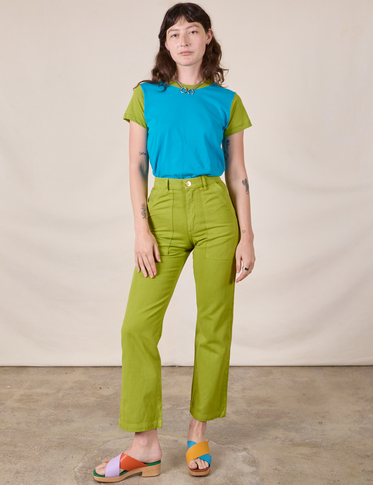 Alex is wearing Mismatched Tee in Blue &amp; Green and gross green Work Pants