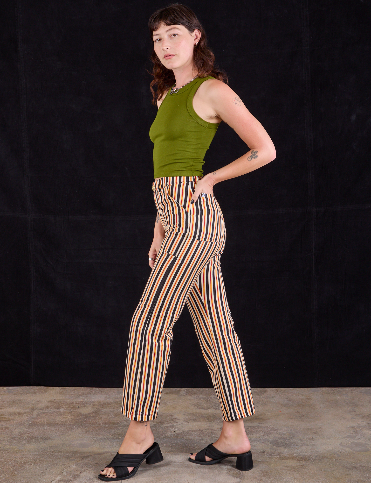 Side view of Work Pants in Autumn Stripe and summer olive Racerback Tank on Alex