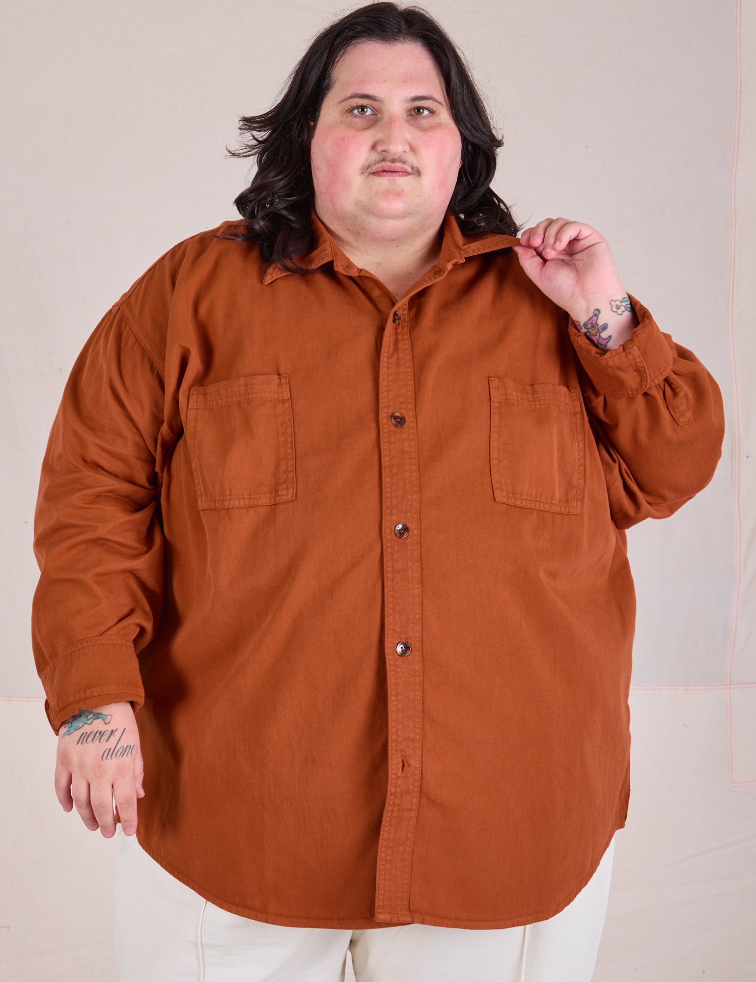 Sam is wearing a buttoned up Twill Overshirt in Burnt Terracotta