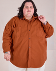 Sam is wearing a buttoned up Twill Overshirt in Burnt Terracotta