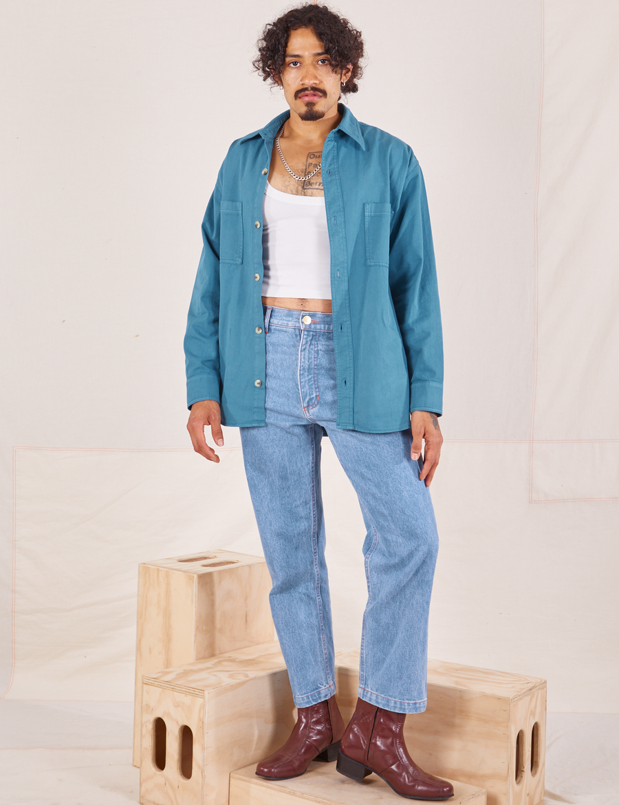 Jesse is wearing Oversize Overshirt in Marine Blue, vintage off-white Cropped Tank Top and light wash Frontier Jeans