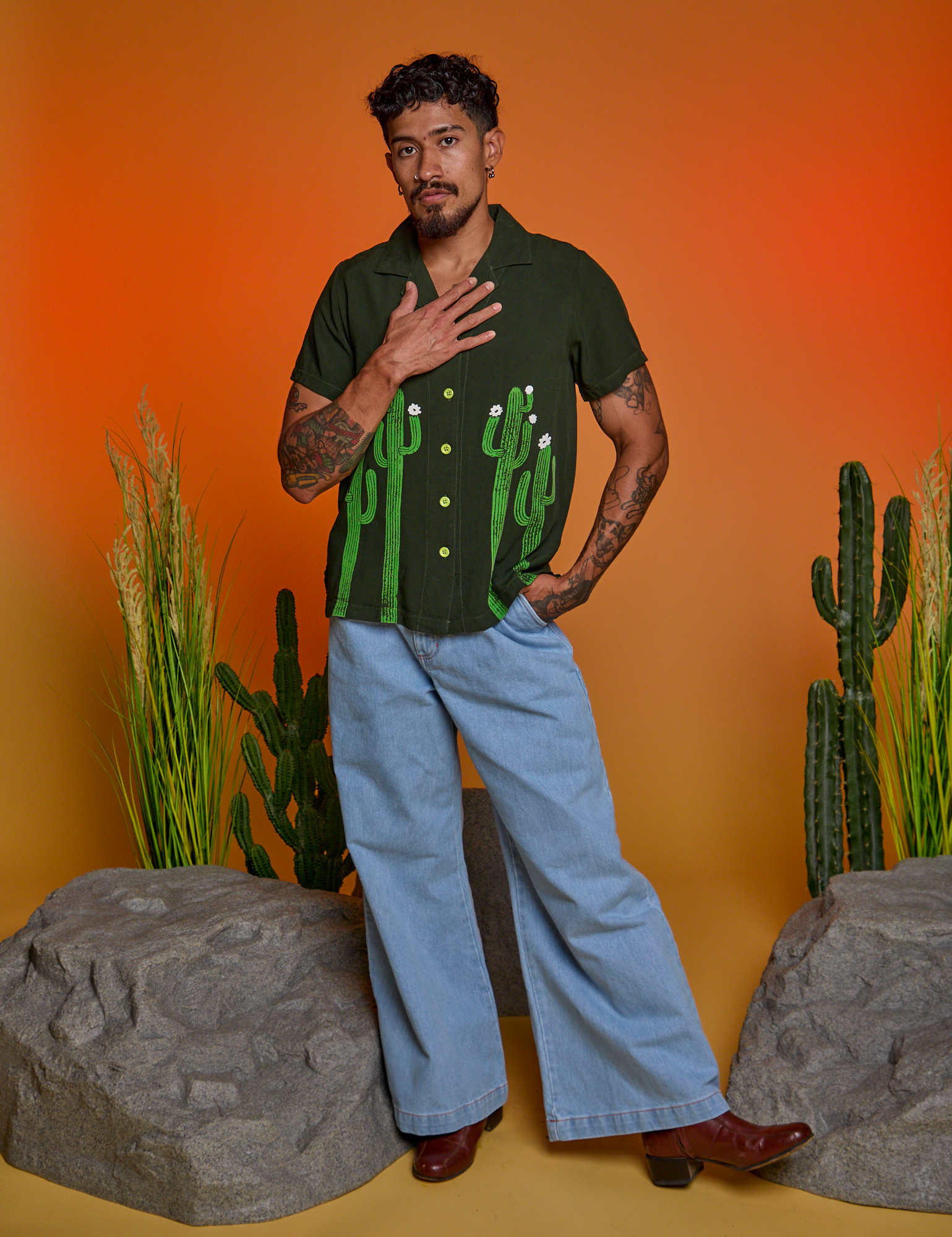 Jesse is wearing Paintstamped Pantry Button-Up in Cactus and light wash Indigo Wide Leg Trousers