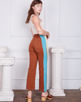 Angled view of Hand-Painted Stripe Western Pants in Burnt Terracotta worn by Alex