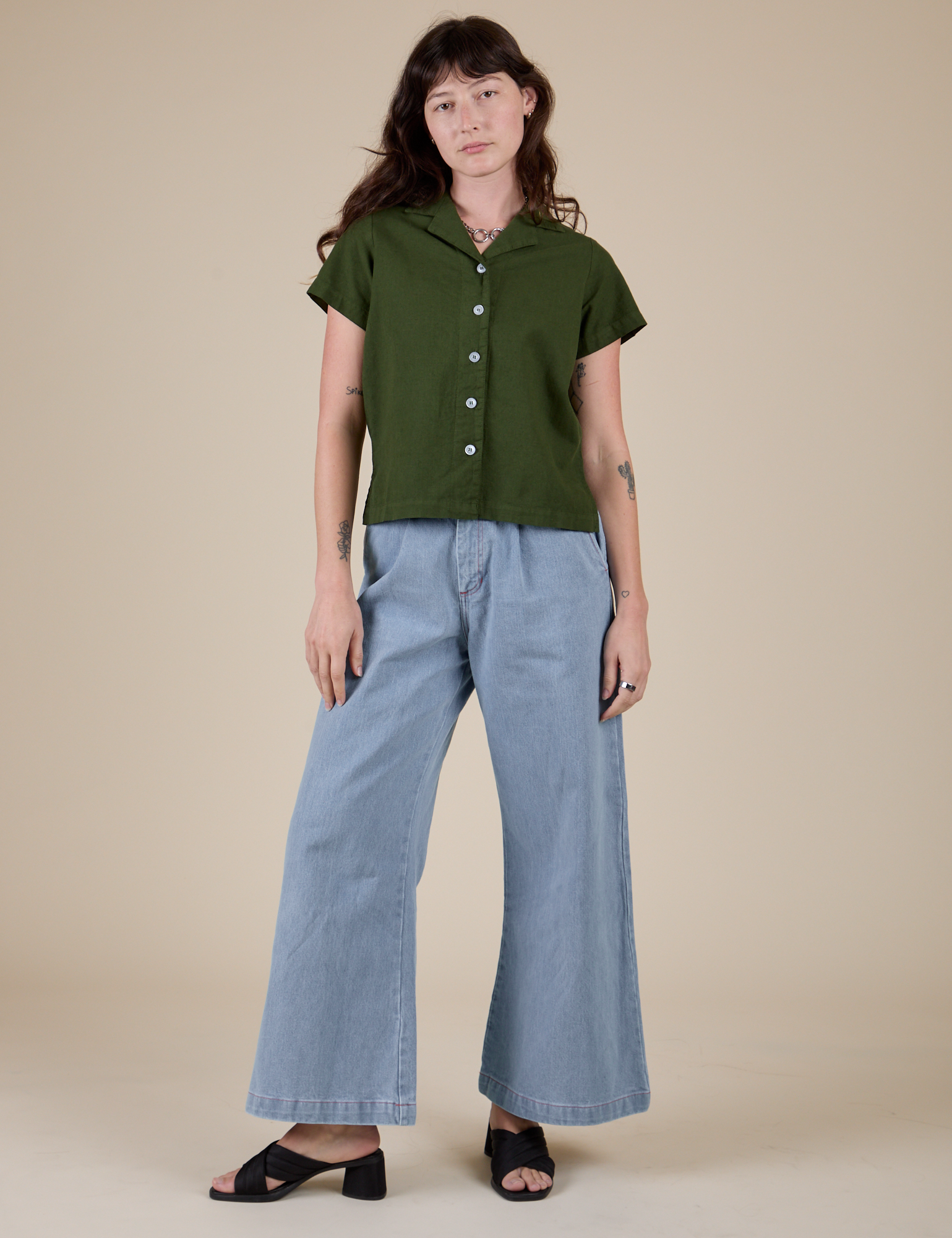 Alex is wearing Pantry Button-Up in Evergreen and light wash Indigo Wide Leg Trousers