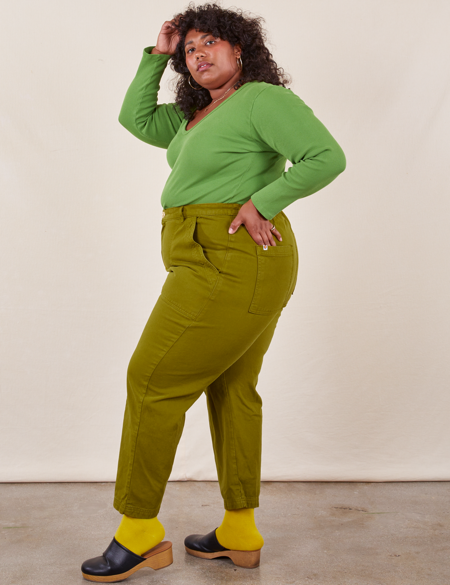 Work Pants in Olive Green side view on Morgan wearing bright olive Long Sleeve V-Neck Tee