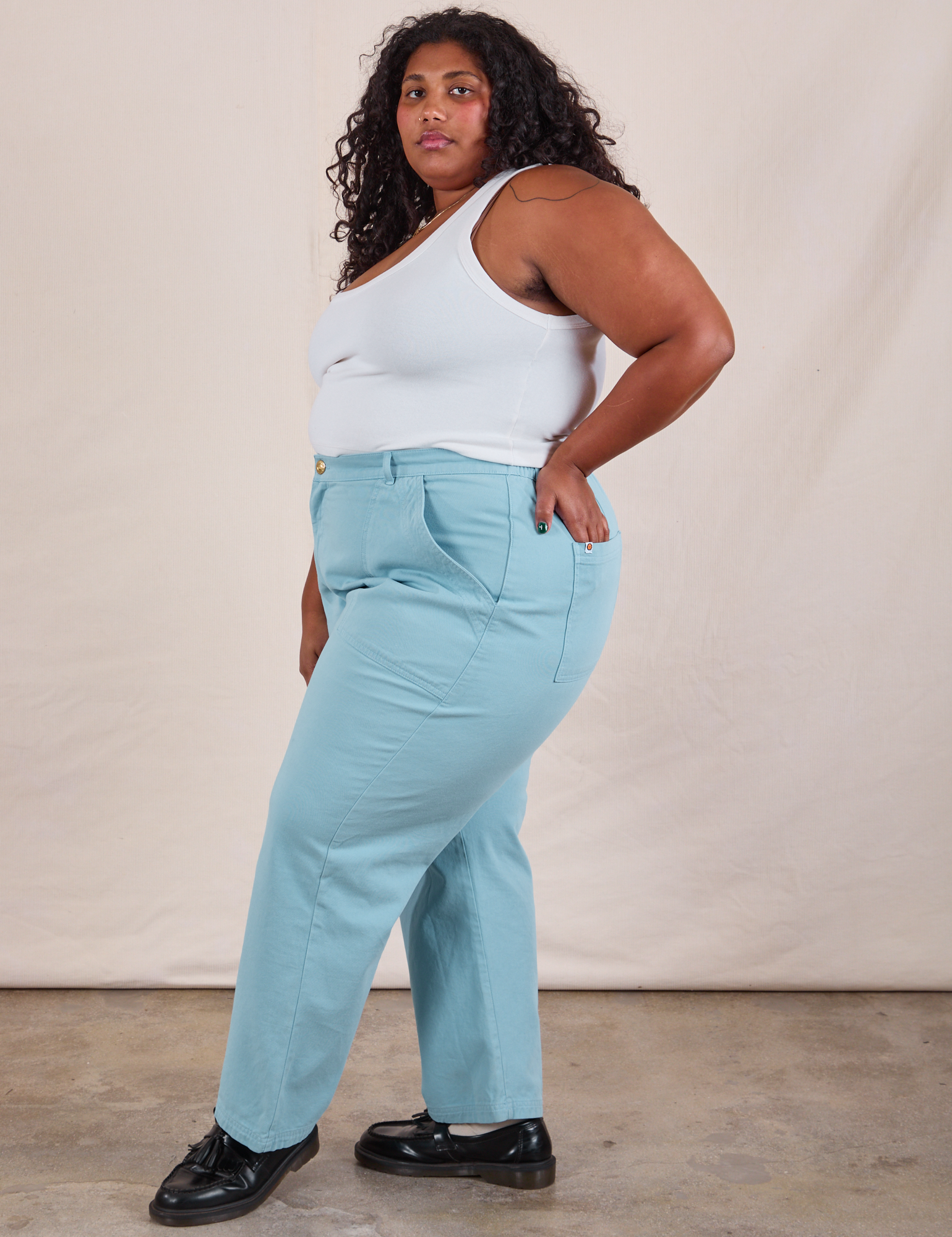 Side view of Work Pants in Baby Blue and Cropped Tank in Vintage Tee Off-White