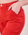 Close up of Alex's hand in the front pocket of Work Pants in Mustang Red