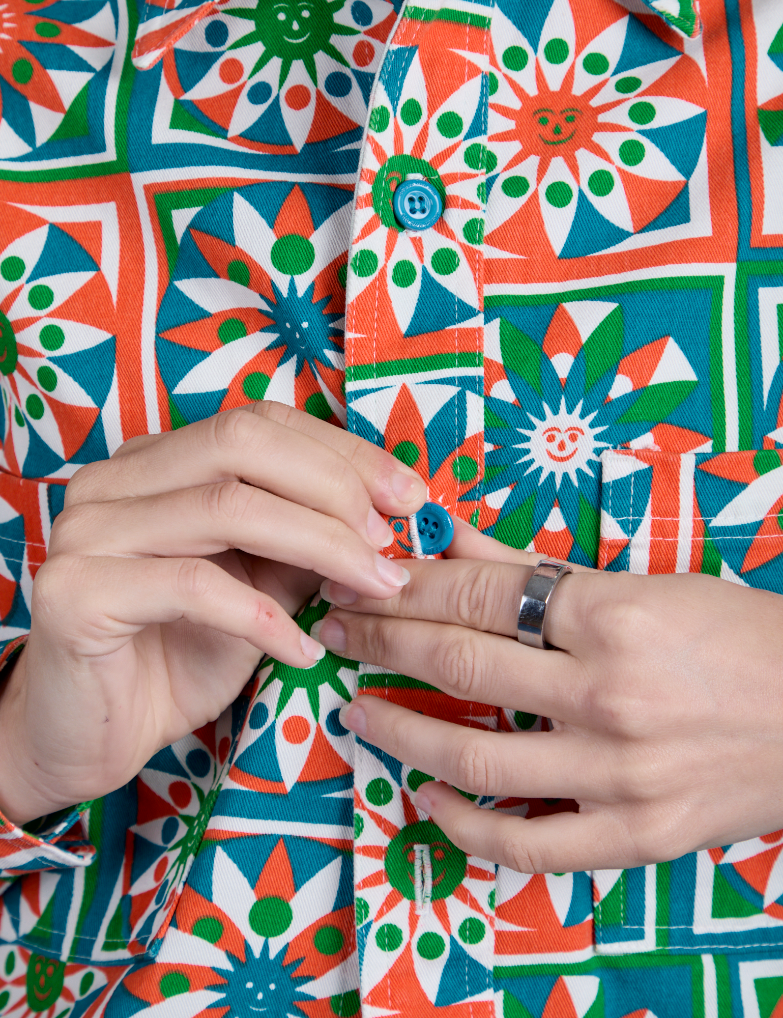 Close up of Alex buttoning up Cropped Overshirt in Quilt Print
