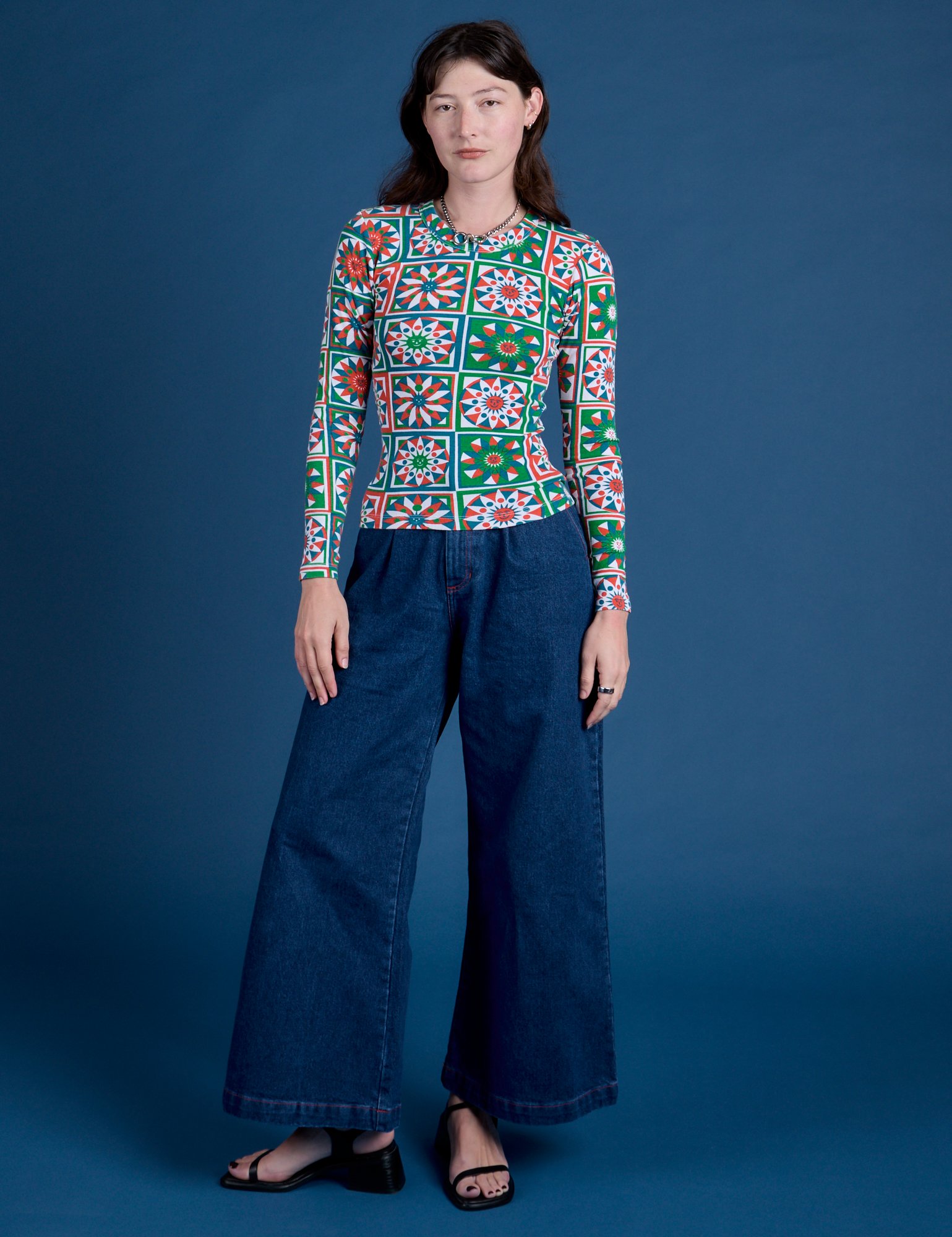 Alex is wearing Long Sleeve Baby Tee in Quilt Print and dark wash Indigo Wide Leg Trousers