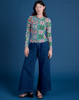Alex is wearing Long Sleeve Baby Tee in Quilt Print and dark wash Indigo Wide Leg Trousers