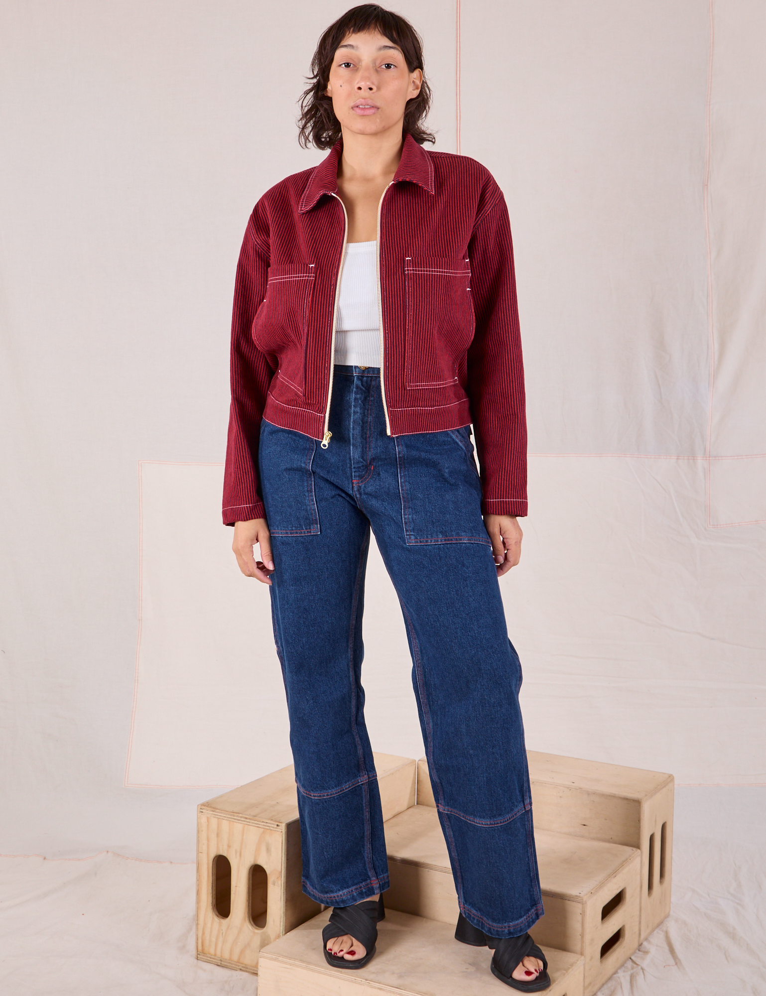 Tiara is wearing Mechanic Jacket in Mustang Red paired with dark wash Carpenter Jeans