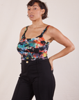 Angled view of Cropped Cami in Rainbow Magic Waters and black Western Pants worn by Tiara