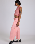 Side view of Drop Pocket Cargo Pants in Baby Pink and matching muscle tee on Kira