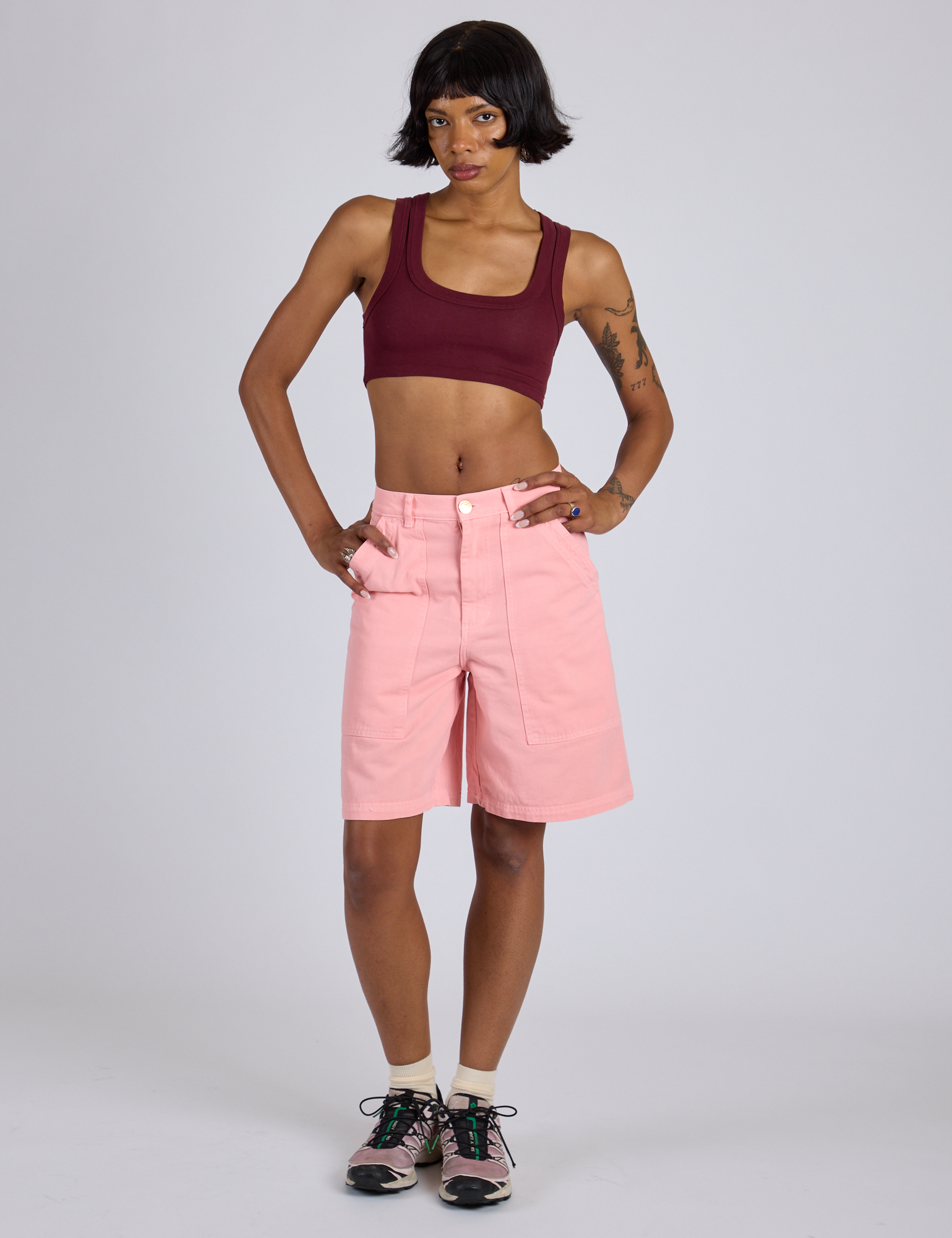 Kira is wearing Longline Work Shorts in Baby Pink and red wine mini Tank