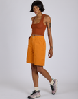 Angled front view of Longline Work Shorts in Creamsicle Orange and burnt terracotta Cropped Tank