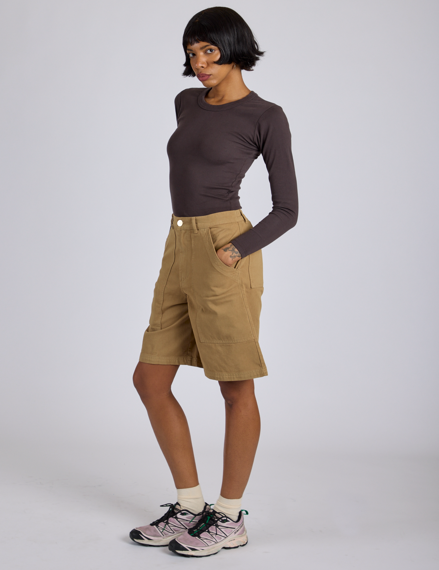 Side view of Longline Work Shorts in Desert Brown and espresso brown Long Sleeve Baby Tee on Kira