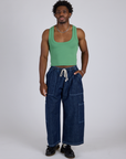 Isaac is wearing Cropped Tank Top in Seafoam Green and dark wash Denim Drop Pocket Pants