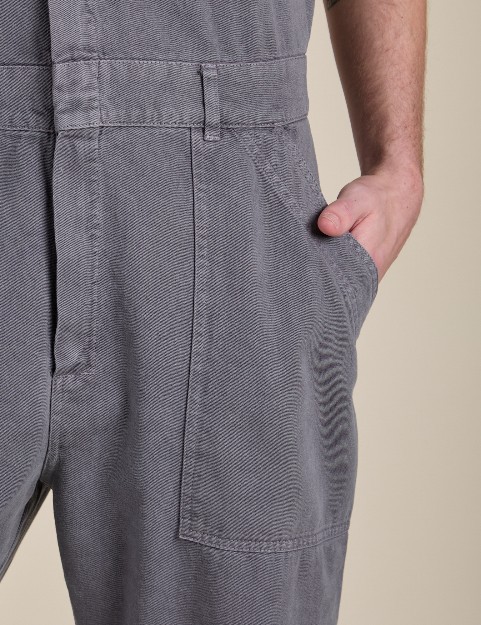 Close up of Quinn's hand in the front pocket of Short Sleeve Jumpsuit in Washed Grey