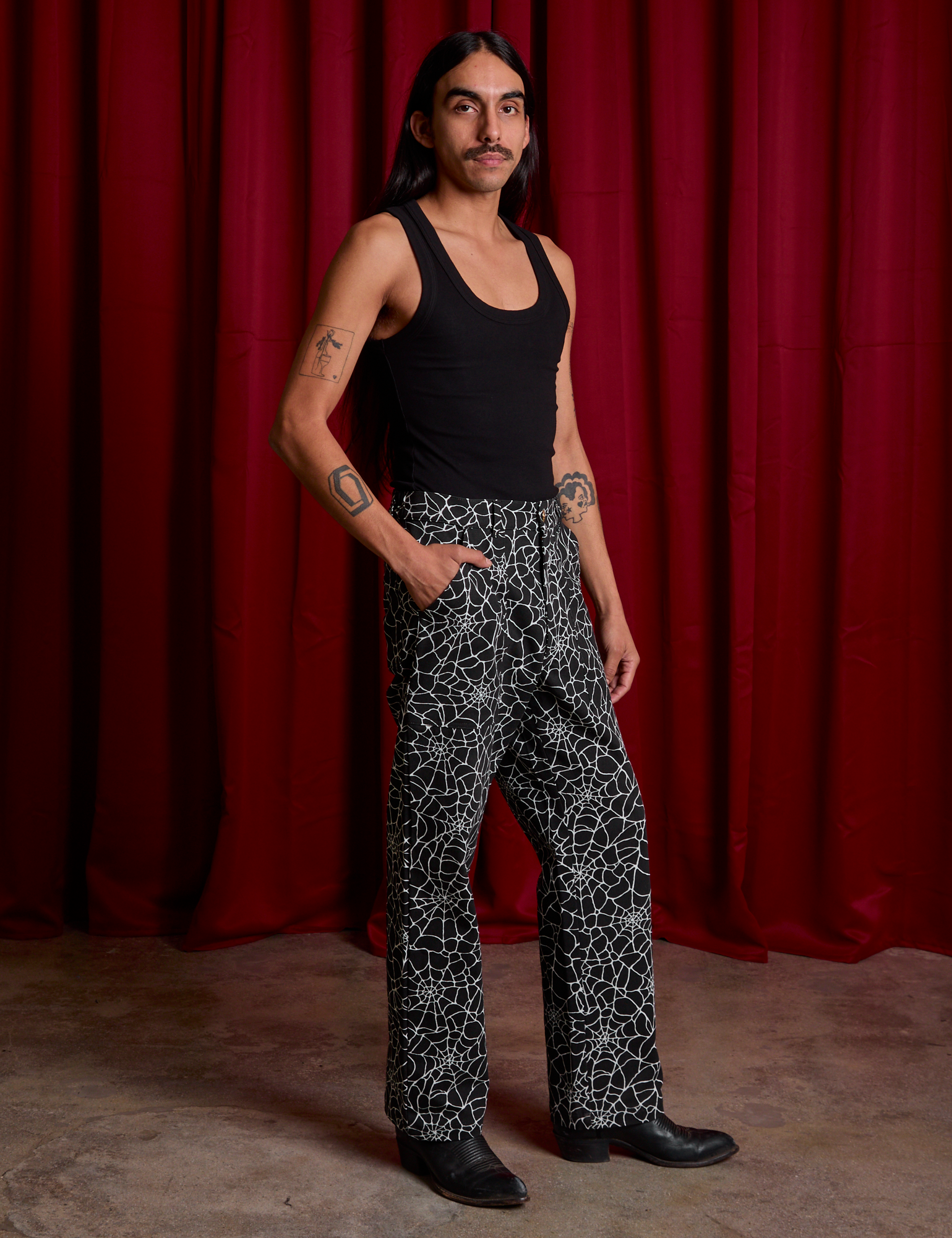 Angled front view of Work Pants in Spiderwebs and black Cropped Tank on Anthony